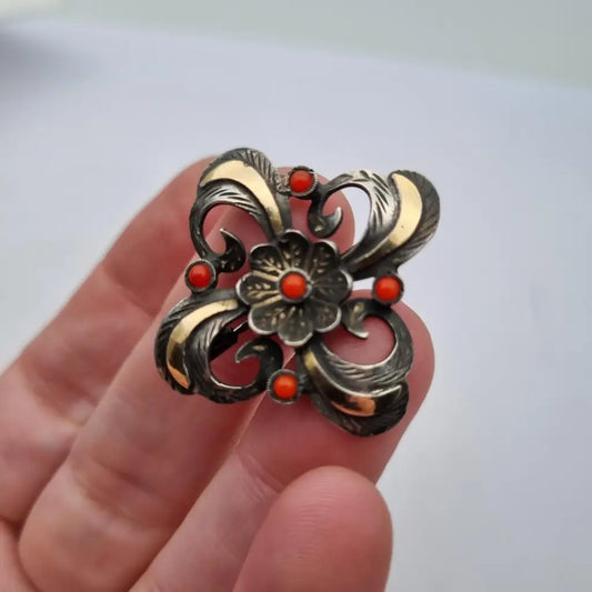 Broche Art Decó en plata con piedra roja y diseño floral detalles dorados