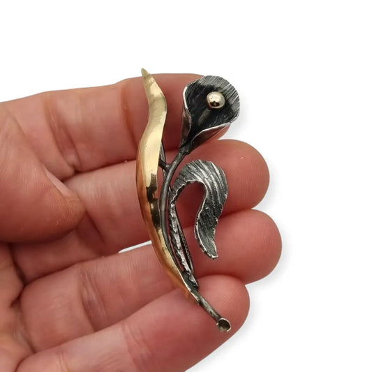 Broche de solapa flor plata para mujer años 50 con detalles dorados.