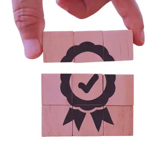 Ícono de premio estilo cinta con una marca de verificación, ensamblado a partir de bloques de madera rosa.