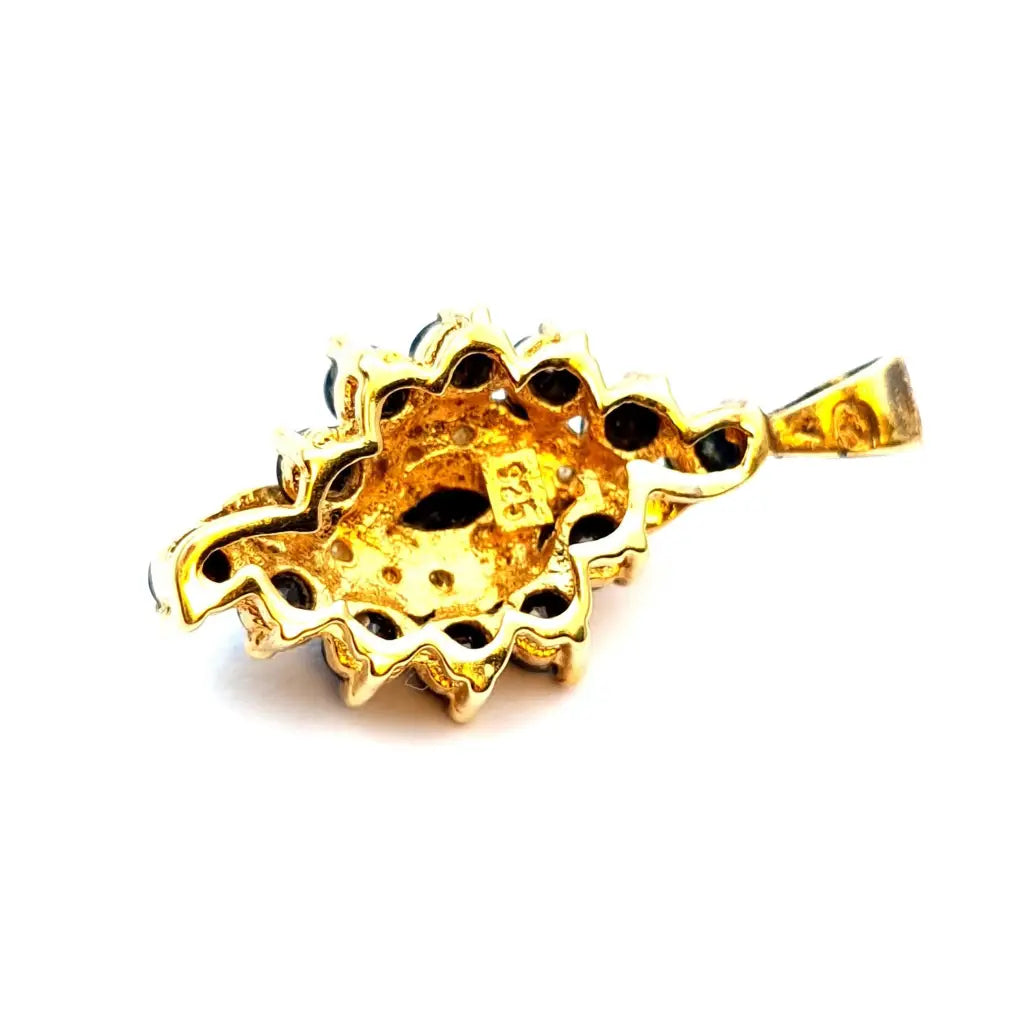 Colgante de plata dorada con piedras azules y blancas en forma lágrima.