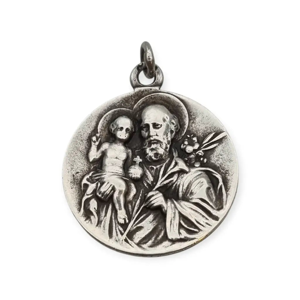 Medalla religiosa antigua en plata maciza de San José y el Niño fechada 1920.