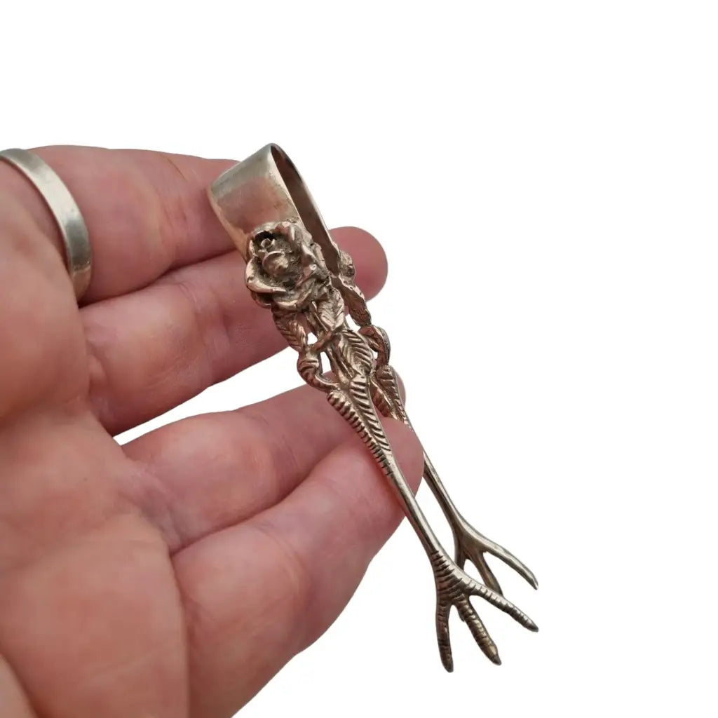 Pinzas de azucar pequeñas plata decorado con rosas y patas pollo.