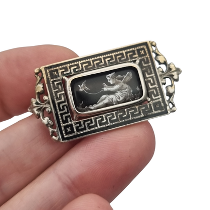 Antique rectangular metal and black enamel brooch with a classical scene, late 19th century