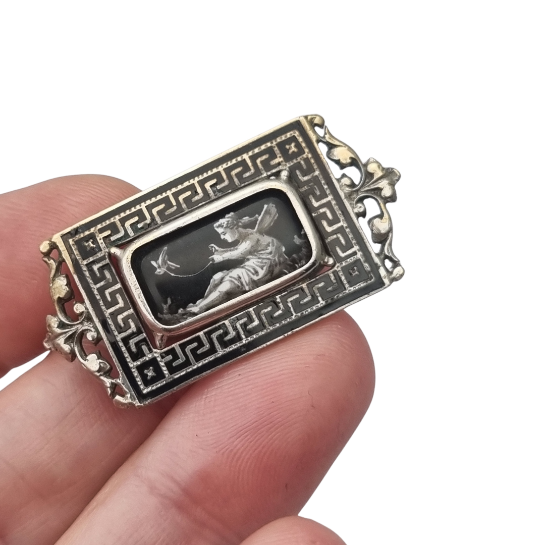 Antique rectangular metal and black enamel brooch with a classical scene, late 19th century
