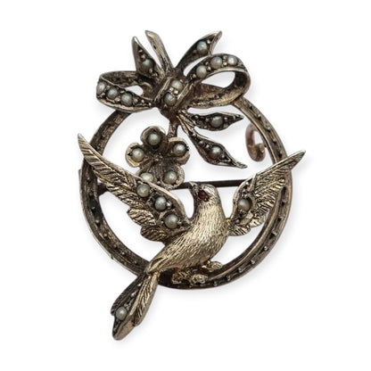 Broche eduardiano en plata con pájaro lazo perlas y rubí circa 1910