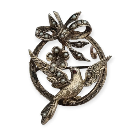 Broche eduardiano en plata con pájaro lazo perlas y rubí circa 1910