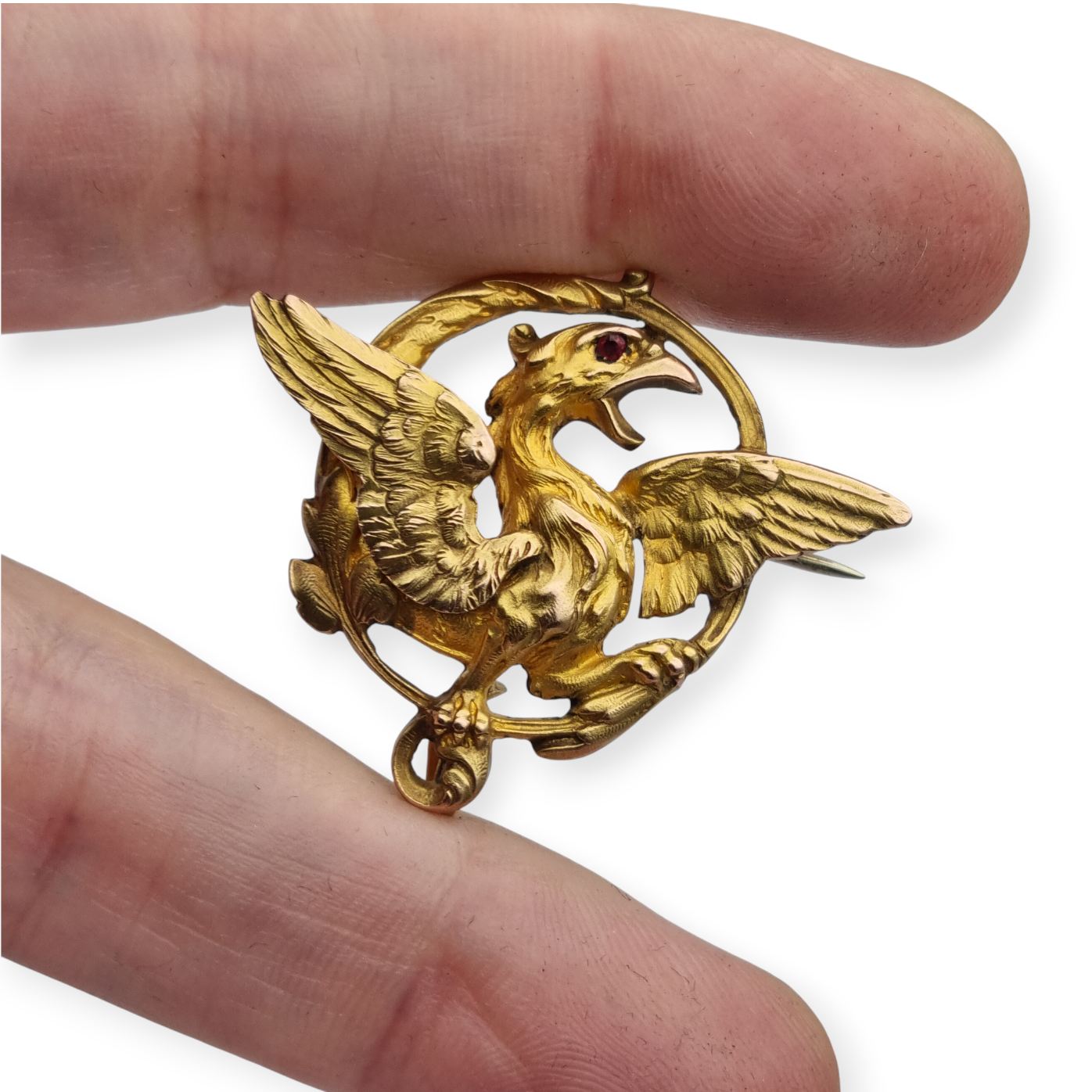 Broche Art Nouveau de grifo ORIA en oro laminado y ojo de rubí, circa 1910