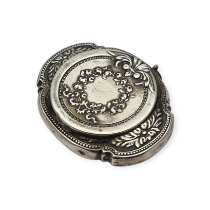 Antigua Polvera para chatelaine Modernista de plata con espejo interior, diseño floral, circa 1920.