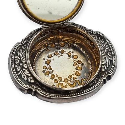 Antigua Polvera para chatelaine Modernista de plata con espejo interior, diseño floral, circa 1920.
