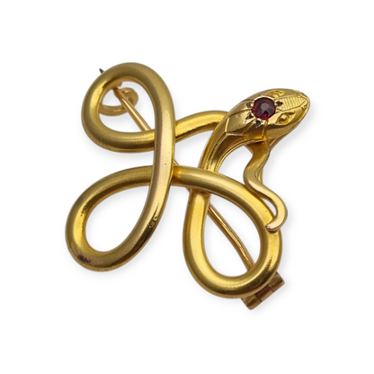 Broche francés FIX con serpiente entrelazada., oro laminado y piedra roja circa 1910