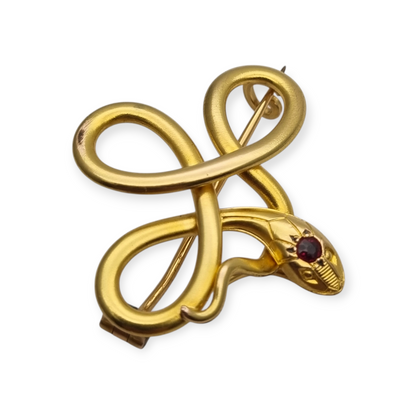 Broche francés FIX con serpiente entrelazada., oro laminado y piedra roja circa 1910