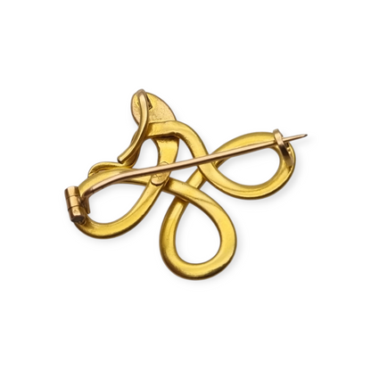 Broche francés FIX con serpiente entrelazada., oro laminado y piedra roja circa 1910