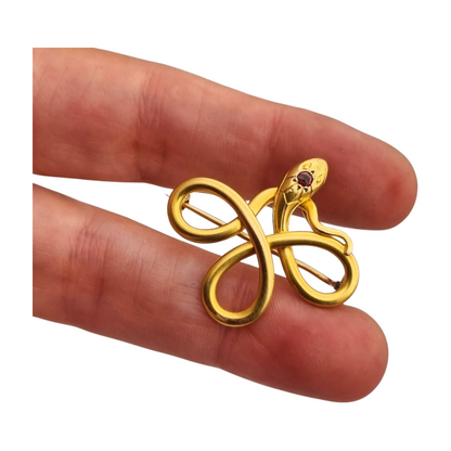 Broche francés FIX con serpiente entrelazada., oro laminado y piedra roja circa 1910