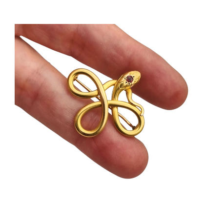 Broche francés FIX con serpiente entrelazada., oro laminado y piedra roja circa 1910