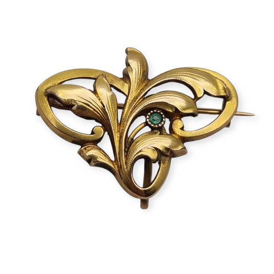 Broche FIX Art Nouveau laminado en oro con piedra verde y diseño floral, circa 1920