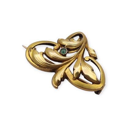 Broche FIX Art Nouveau laminado en oro con piedra verde y diseño floral, circa 1920