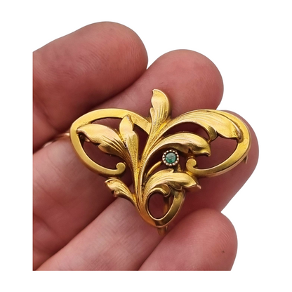 Broche FIX Art Nouveau laminado en oro con piedra verde y diseño floral, circa 1920
