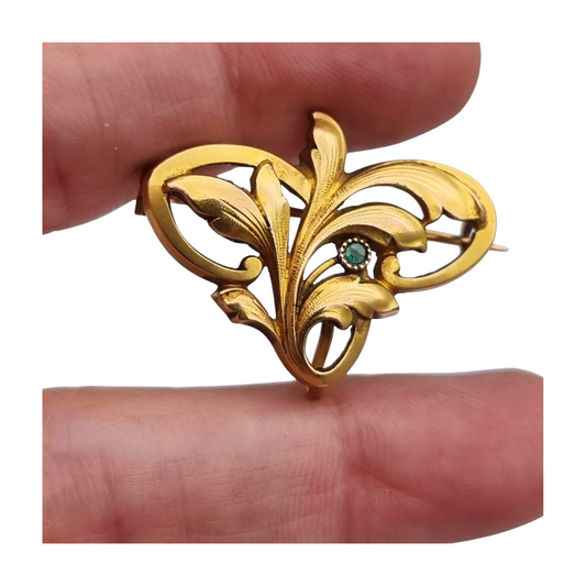 Broche FIX Art Nouveau laminado en oro con piedra verde y diseño floral, circa 1920