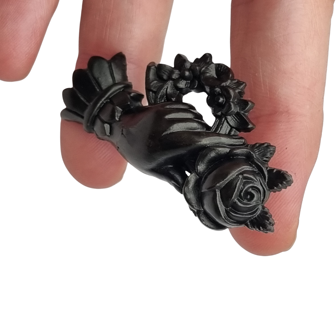 Broche victoriano de mano con rosa y corona floral, probable vulcanita, joyería sentimental circa 1870–1890