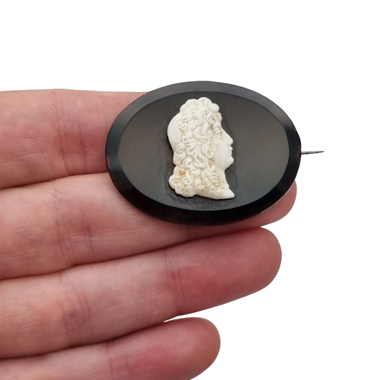 Vintage brooch with applied Neoclassical cameo, oval black plate and classic profile, circa 1930–1960