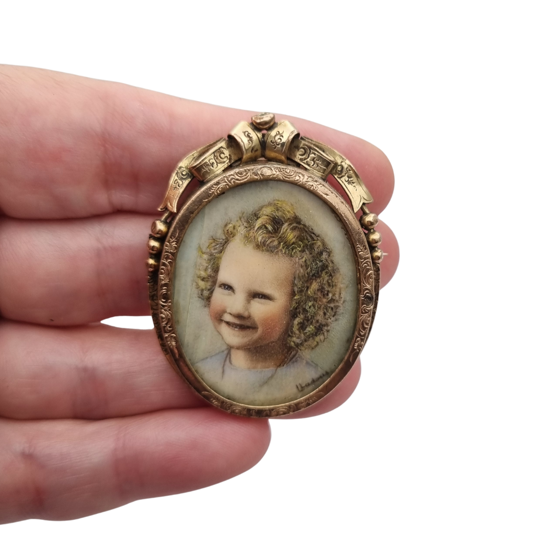 Broche portarretrato Belle Époque de metal dorado con miniatura de retrato infantil estilo Luis XV, circa 1890-1910