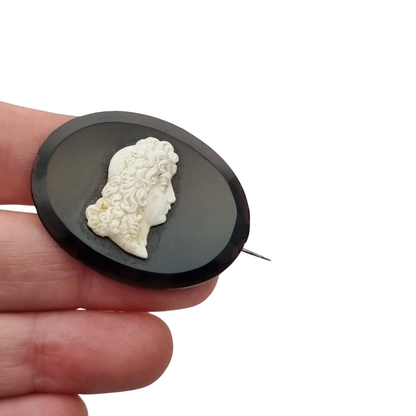 Vintage brooch with applied Neoclassical cameo, oval black plate and classic profile, circa 1930–1960