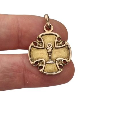 Medalla religiosa antigua en cruz calada dorada con cáliz, circa 1920