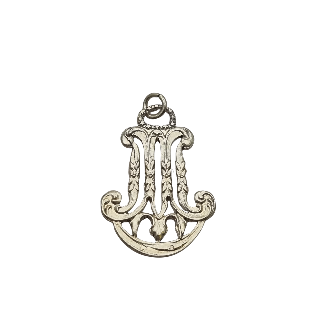 Colgante mariano monograma M en plata calada Art Nouveau, joya religiosa, circa 1900–1925