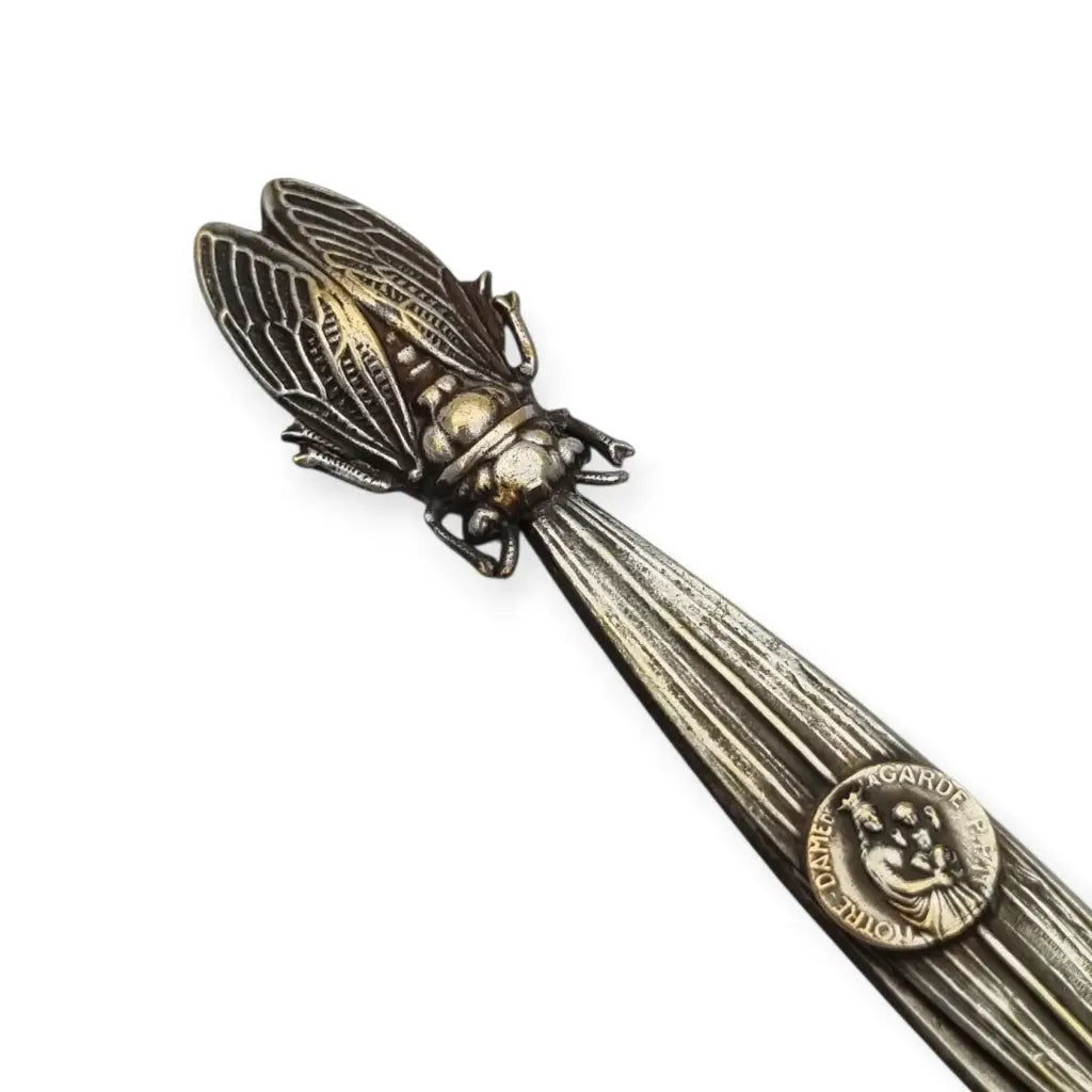 Abrecartas vintage con cigarra en relieve y medalla religiosa de Notre-Dame