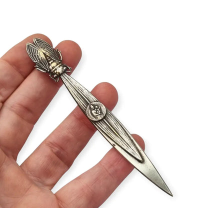 Abrecartas vintage con cigarra en relieve y medalla religiosa de Notre-Dame