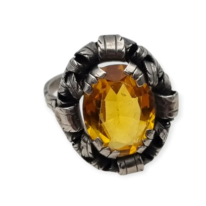 Anillo antiguo Art Deco en plata con cristal amarillo ovalado y diseño floral.