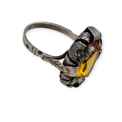 Anillo antiguo Art Deco en plata con cristal amarillo ovalado y diseño floral.