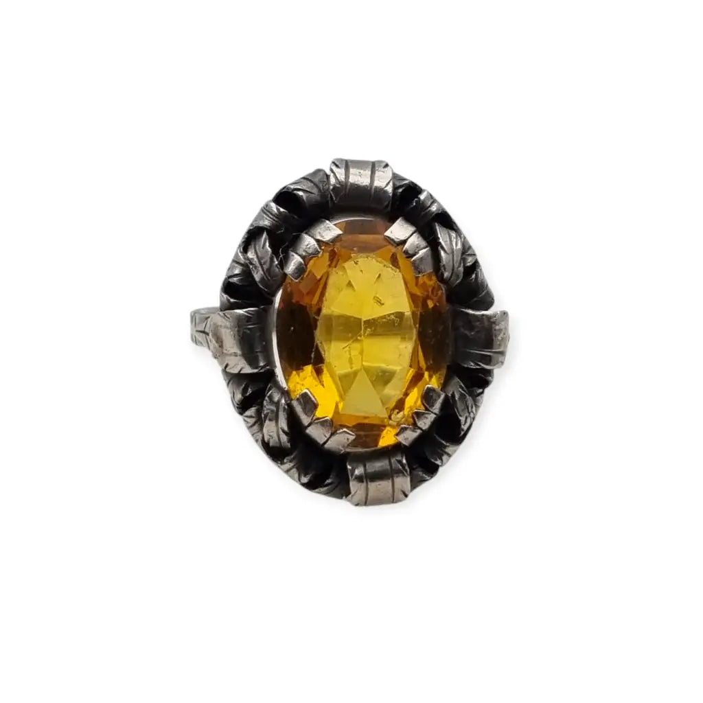 Anillo antiguo Art Deco en plata con cristal amarillo ovalado y diseño floral.