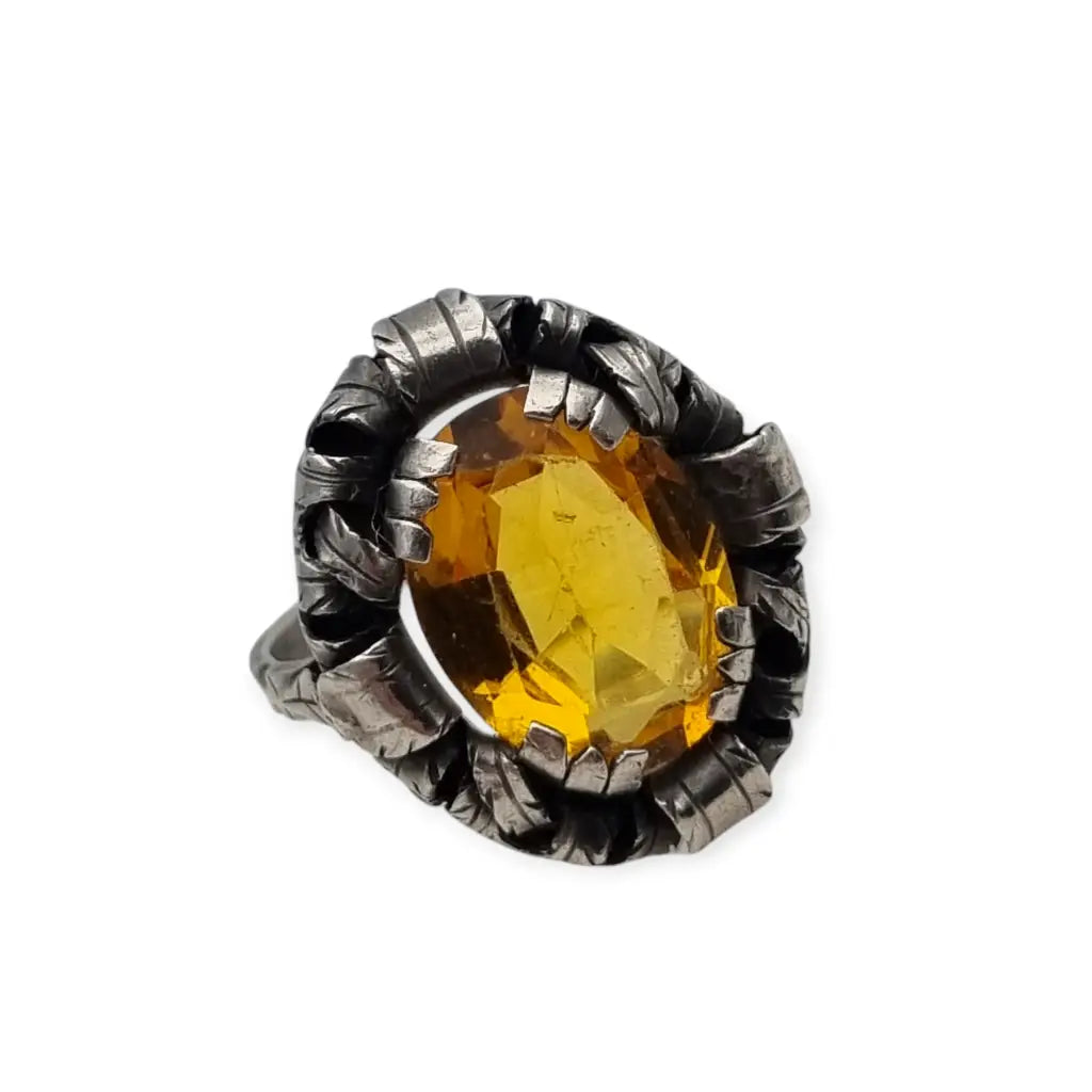 Anillo antiguo Art Deco en plata con cristal amarillo ovalado y diseño floral.