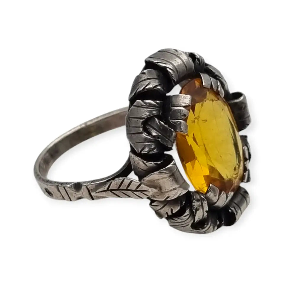 Anillo antiguo Art Deco en plata con cristal amarillo ovalado y diseño floral.