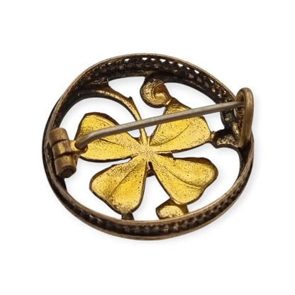 Broche antiguo Art Nouveau en metal dorado flor calada con cristal rojo central