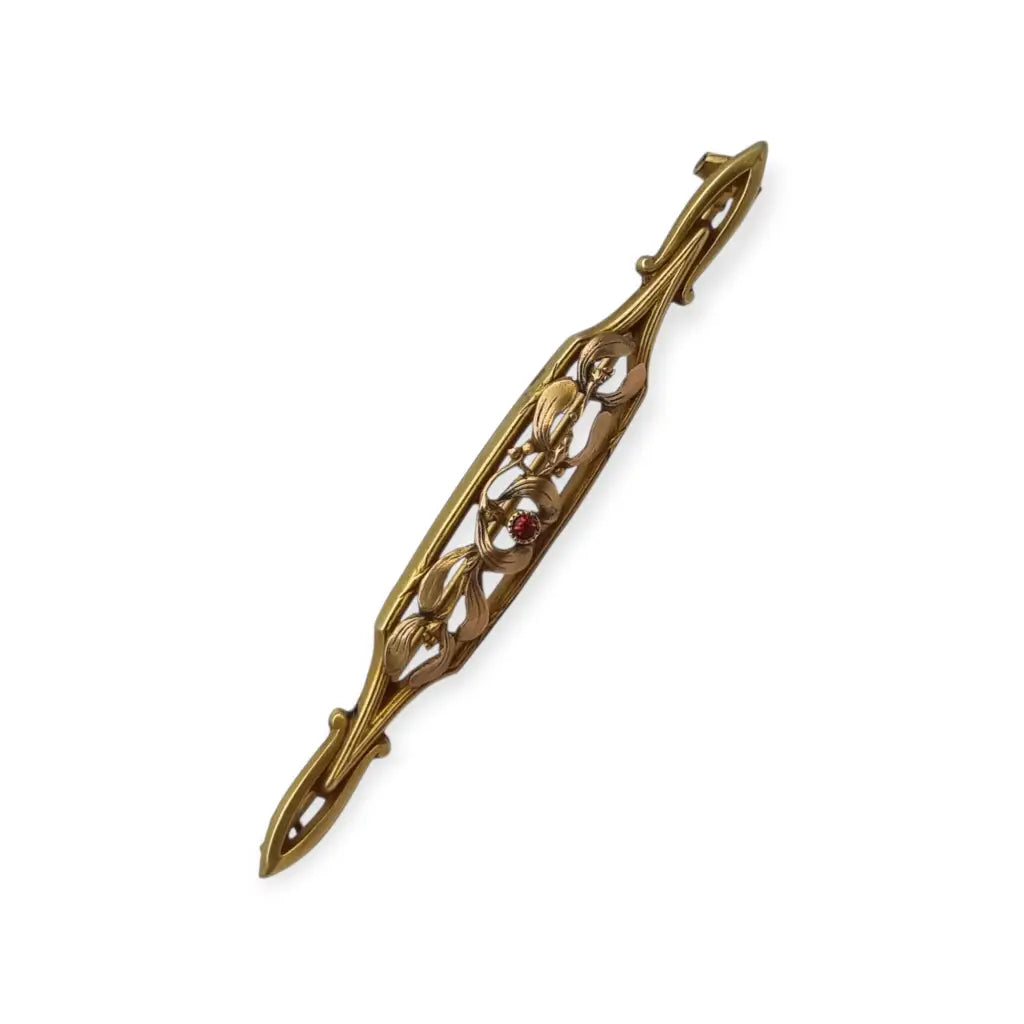 Broche Art Nouveau de Oria en oro laminado con flor calada y cristal rojo Circa