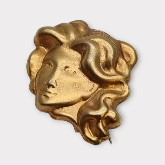 Broche de cabeza contemporáneo marca Sunsilk en latón dorado. Bisutería dorada.
