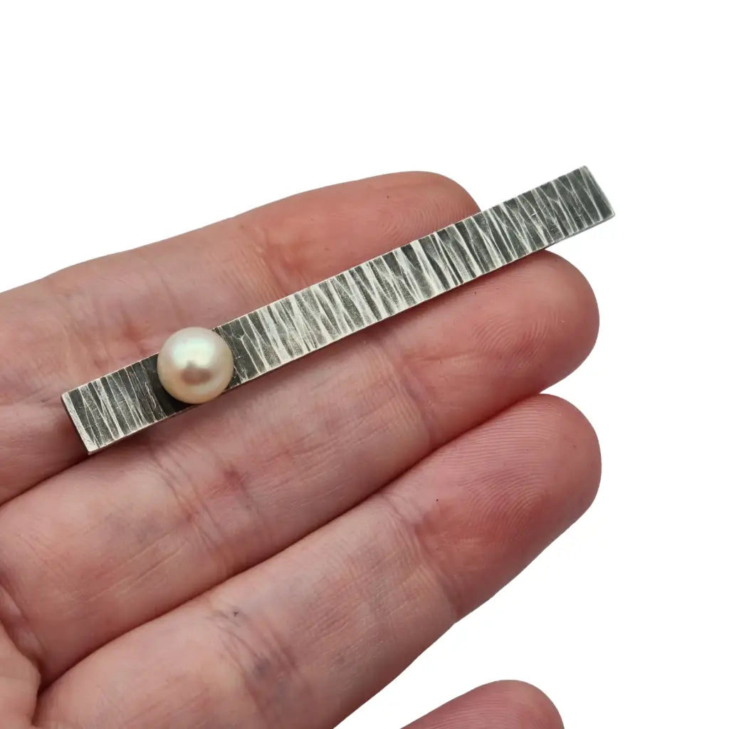 Broche moderno en plata martillada con perla cultivada diseño minimalista