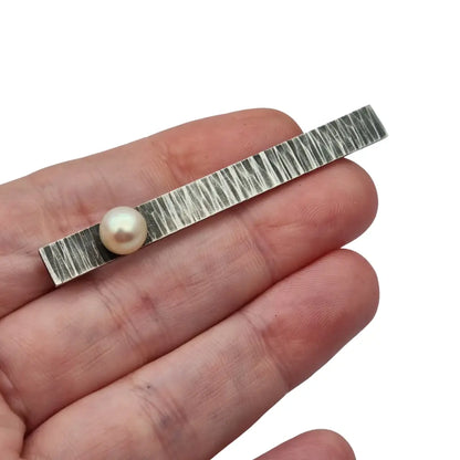 Broche moderno en plata martillada con perla cultivada diseño minimalista