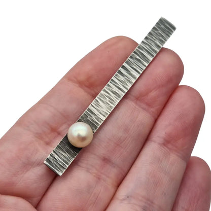 Broche moderno en plata martillada con perla cultivada diseño minimalista