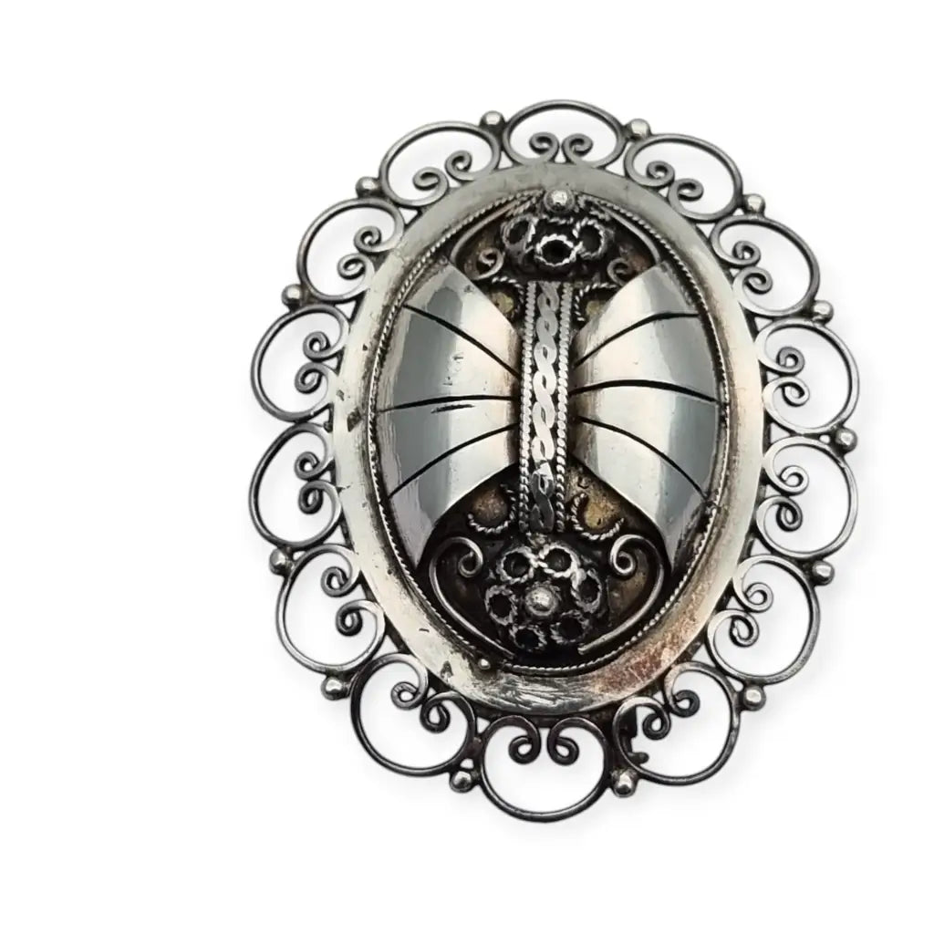 Broche ovalado de plata con filigrana popular detallada y diseño Art Nouveau.