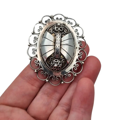 Broche ovalado de plata con filigrana popular detallada y diseño Art Nouveau.