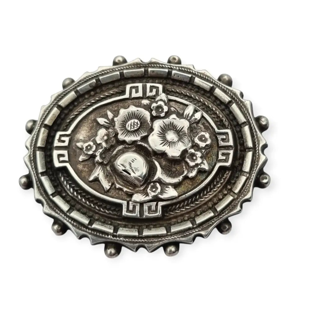Broche relicario victoriano en plata de ley con flores relieve. Circa 1910.