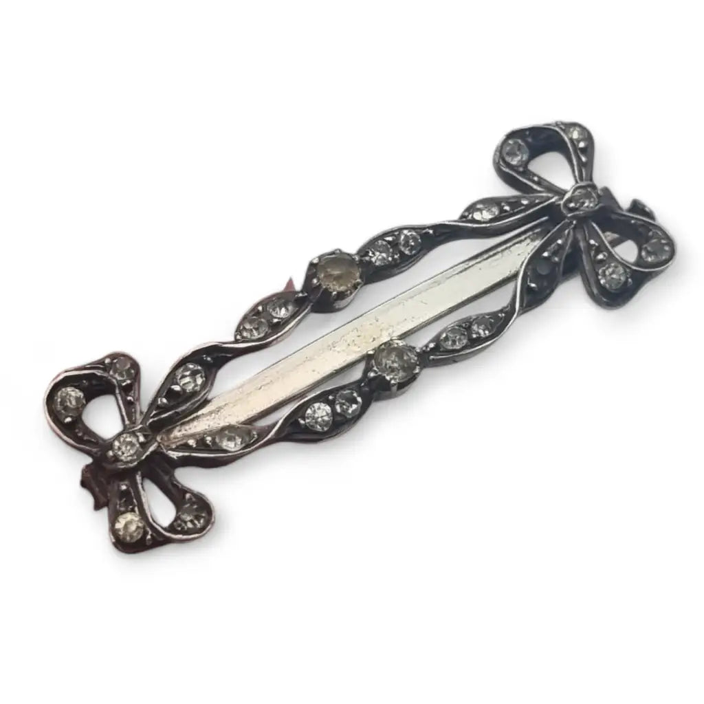 Broche art nouveau de plata con lazos y pedrería blanca para mujer.