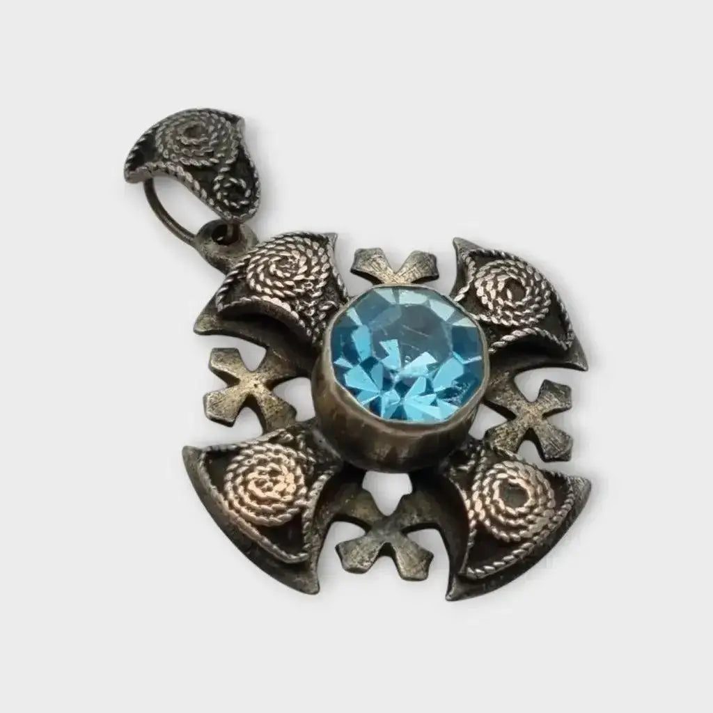 Colgante cruz maltesa de metal plateado con piedra azul decoración