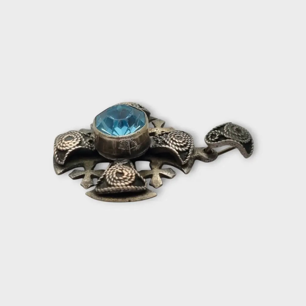 Colgante cruz maltesa de metal plateado con piedra azul decoración