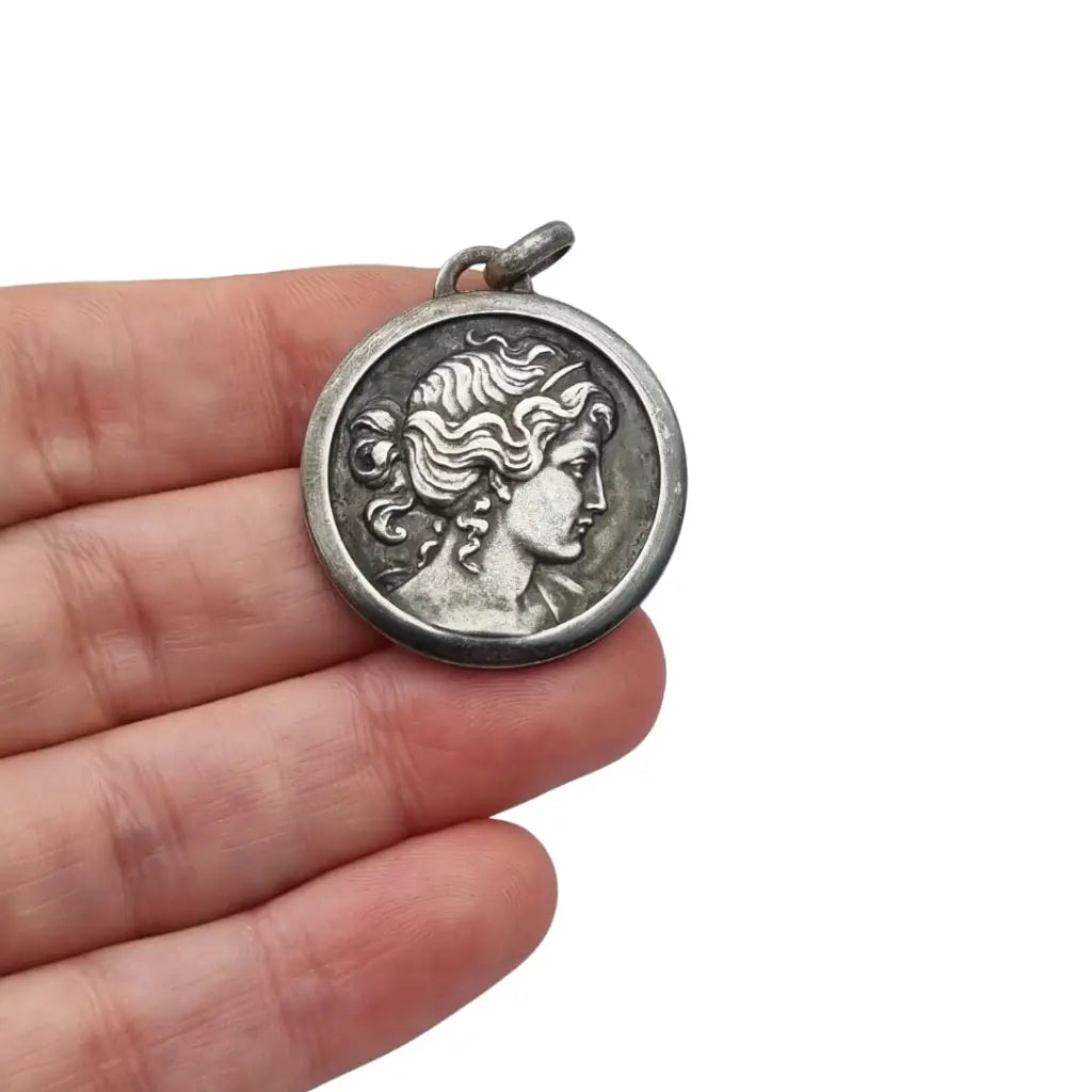 Colgante tipo medalla con perfil femenino inspiración grecorromana metal tono