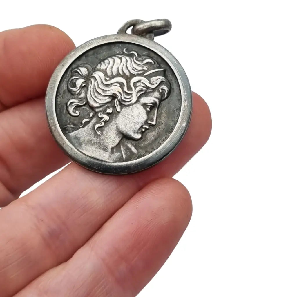 Colgante tipo medalla con perfil femenino inspiración grecorromana metal tono