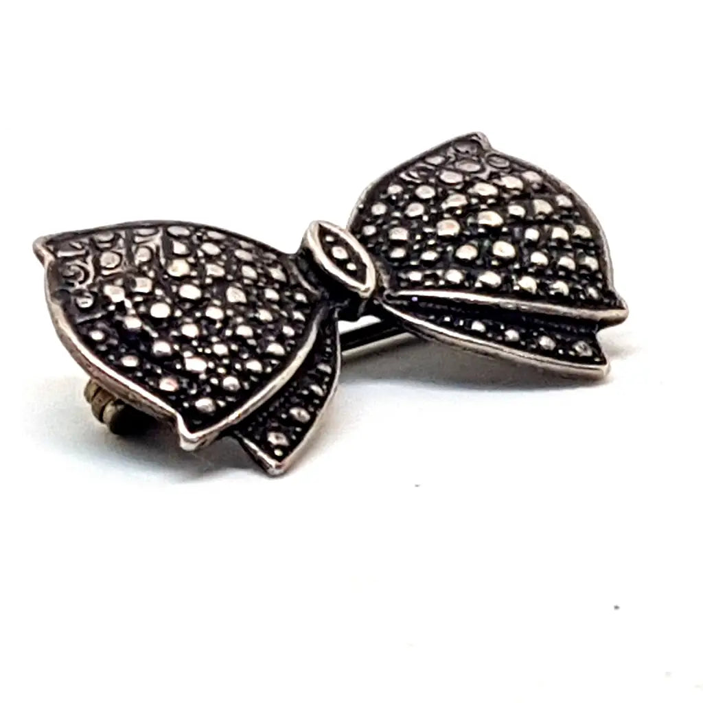 Broche de plata vintage con forma lazo en grabada. Circa 1960. Joyería